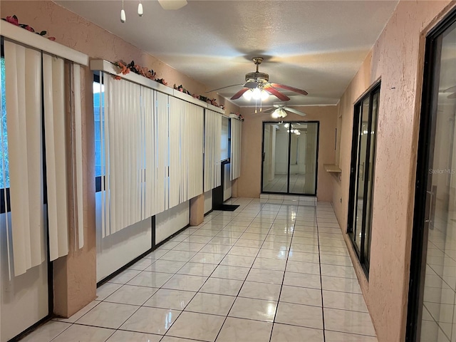 hall featuring a textured ceiling and light tile floors