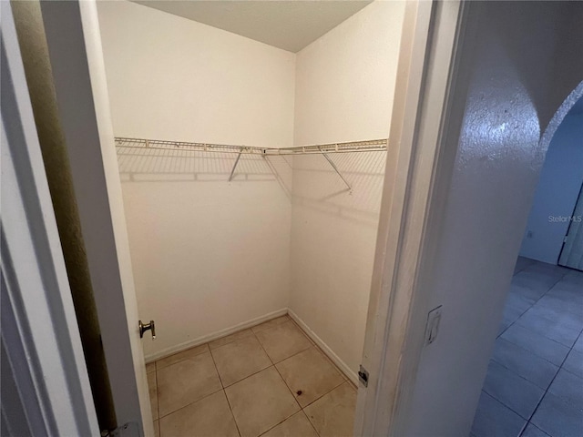 walk in closet featuring tile floors