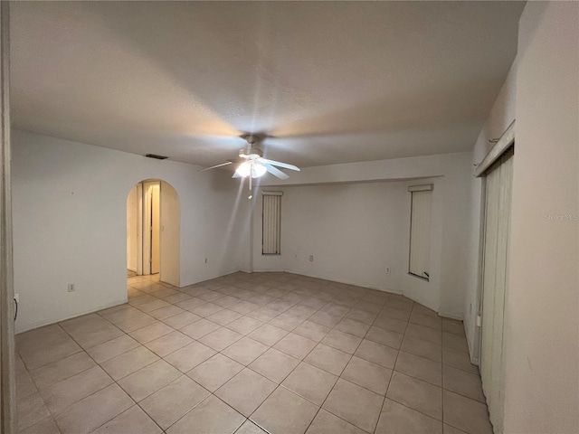 empty room featuring ceiling fan and light tile floors