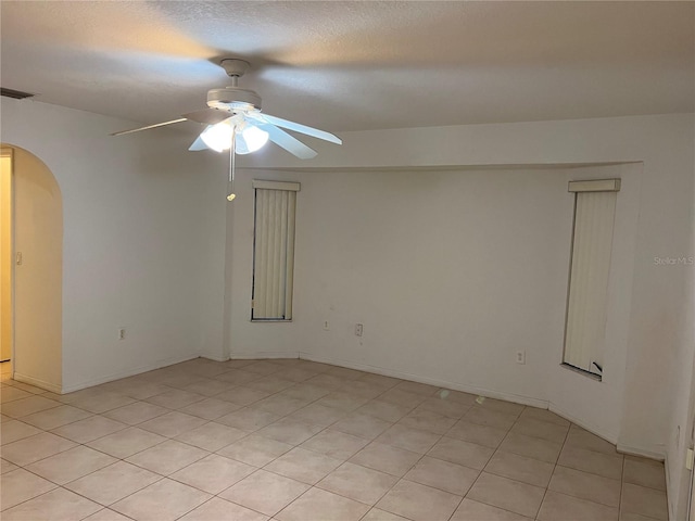 tiled empty room featuring ceiling fan