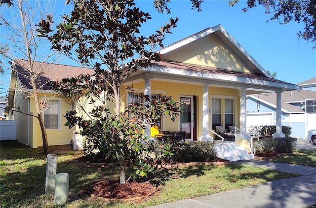 view of front facade with a porch, a front yard, and a garage