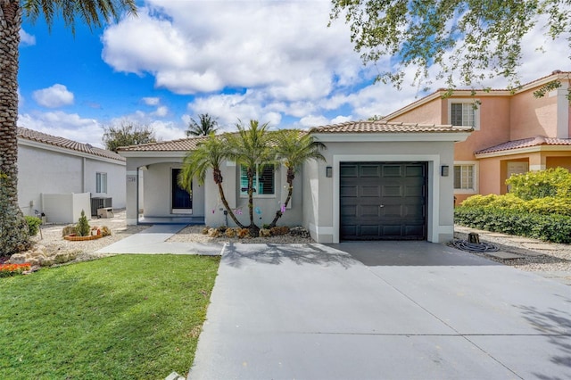 mediterranean / spanish-style home with central AC unit, a garage, and a front lawn