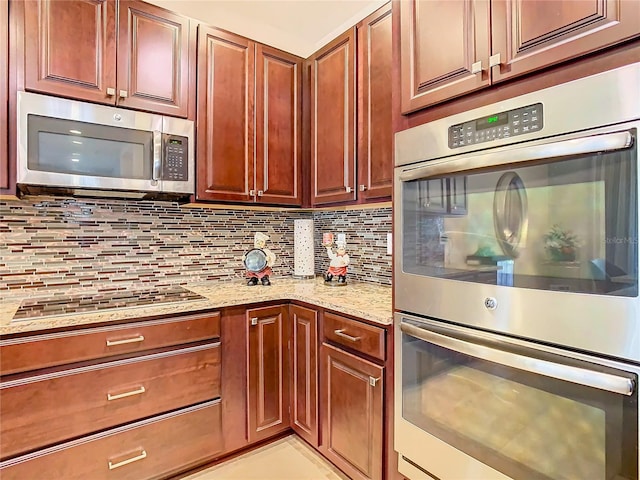 kitchen featuring backsplash, appliances with stainless steel finishes, and light stone counters