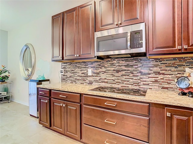 kitchen featuring tasteful backsplash, gas cooktop, light tile floors, and light stone counters