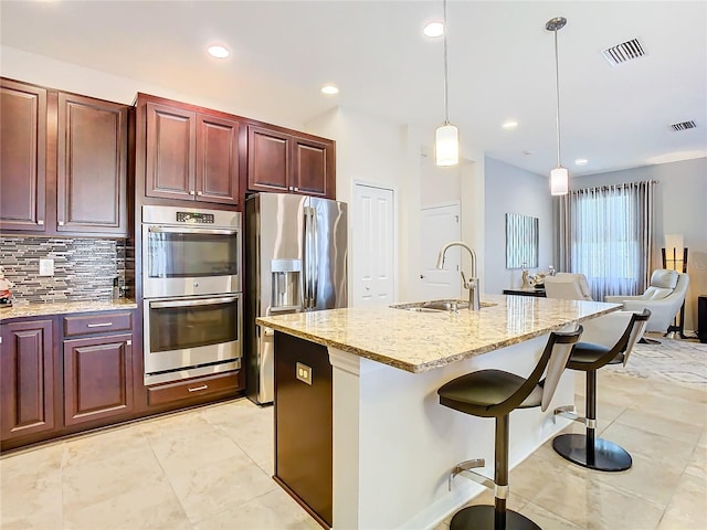 kitchen featuring light tile floors, sink, tasteful backsplash, hanging light fixtures, and stainless steel appliances