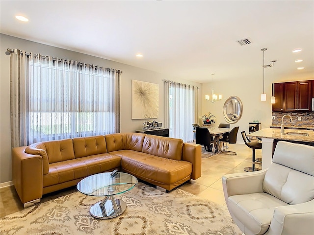 tiled living room with sink and a notable chandelier