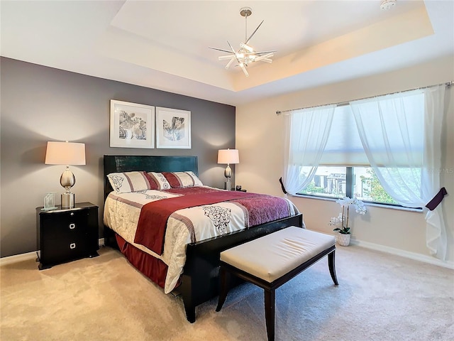 bedroom with carpet, ceiling fan, and a tray ceiling