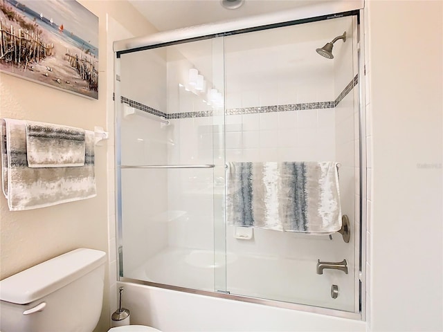 bathroom featuring shower / bath combination with glass door and toilet