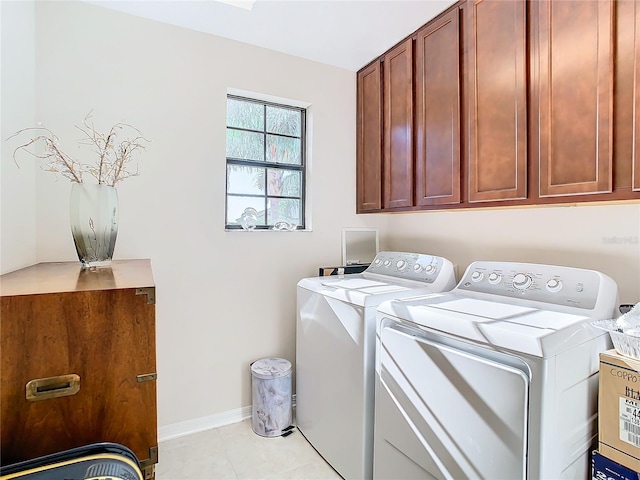 washroom with washer and dryer, cabinets, and light tile floors