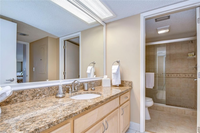 bathroom featuring a textured ceiling, vanity, toilet, and tile flooring