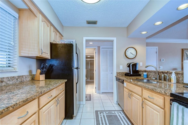 kitchen featuring light brown cabinetry, crown molding, light tile flooring, and a textured ceiling