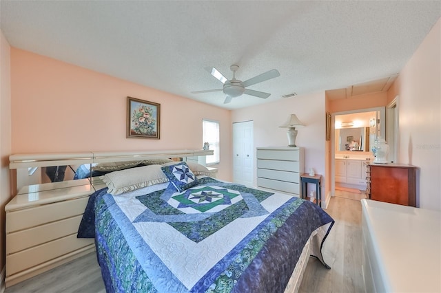 bedroom with a textured ceiling, ceiling fan, visible vents, a closet, and light wood-type flooring