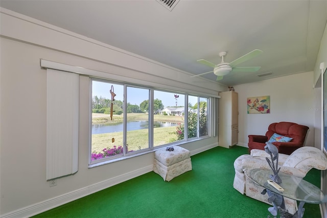 sunroom / solarium featuring a water view, ceiling fan, and visible vents