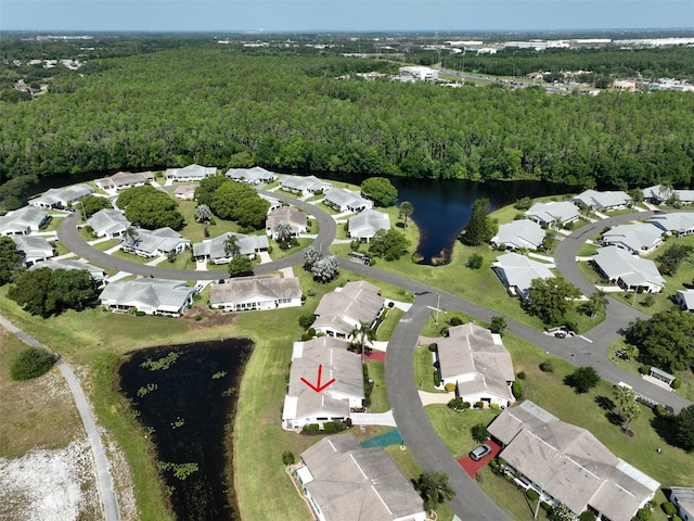 birds eye view of property with a water view, a residential view, and a wooded view