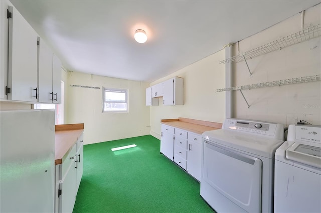 laundry room featuring washer and clothes dryer, dark carpet, and cabinet space