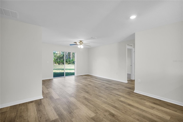 empty room with ceiling fan and hardwood / wood-style flooring