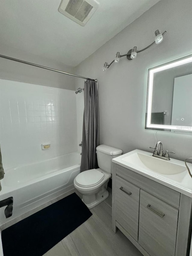 full bathroom with vanity, wood-type flooring, shower / bath combo, and toilet