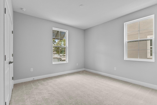 unfurnished room featuring light carpet