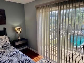 bedroom with baseboards, multiple windows, and access to exterior