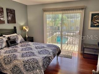 bedroom with access to exterior and wood finished floors