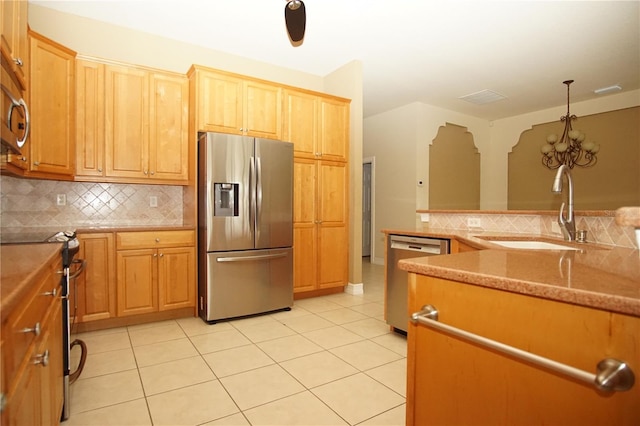 kitchen featuring sink, light tile patterned floors, tasteful backsplash, decorative light fixtures, and stainless steel appliances