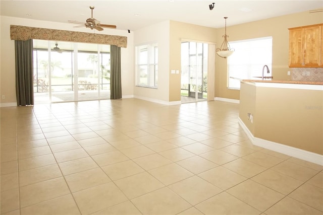 unfurnished room with sink, light tile patterned floors, and ceiling fan