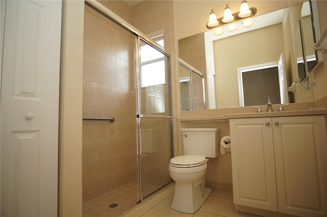 bathroom featuring tile patterned flooring, vanity, a shower with door, and toilet