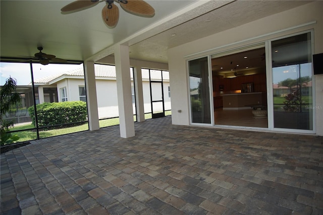 unfurnished sunroom with ceiling fan