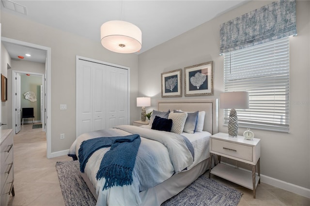 bedroom with a closet and light tile flooring