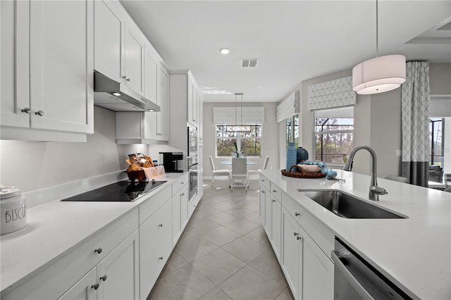 kitchen with sink, white cabinetry, pendant lighting, and light tile floors