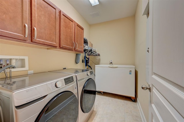 washroom featuring cabinets and washer and dryer