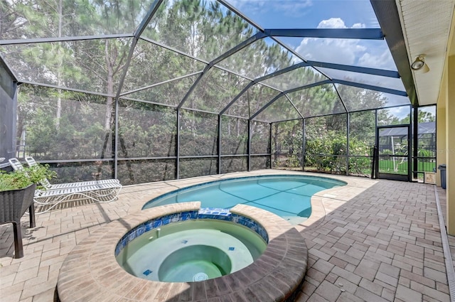 view of pool with a lanai, a patio area, and an in ground hot tub