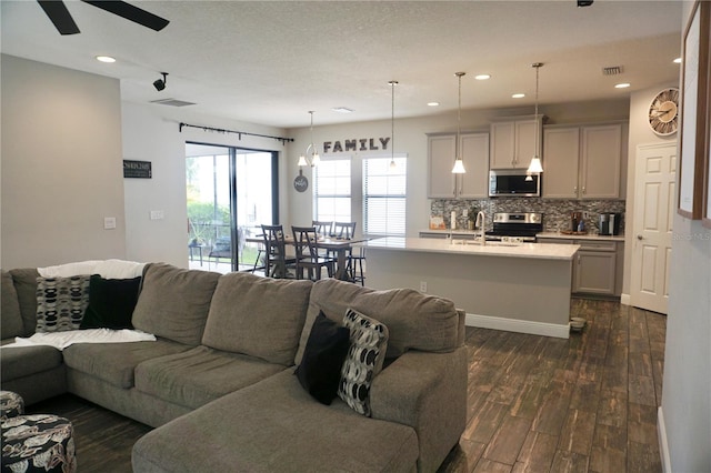 living room featuring sink, dark hardwood / wood-style flooring, and ceiling fan