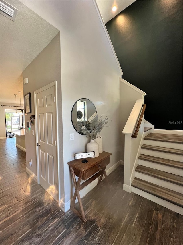 hallway featuring a textured ceiling and dark wood-type flooring