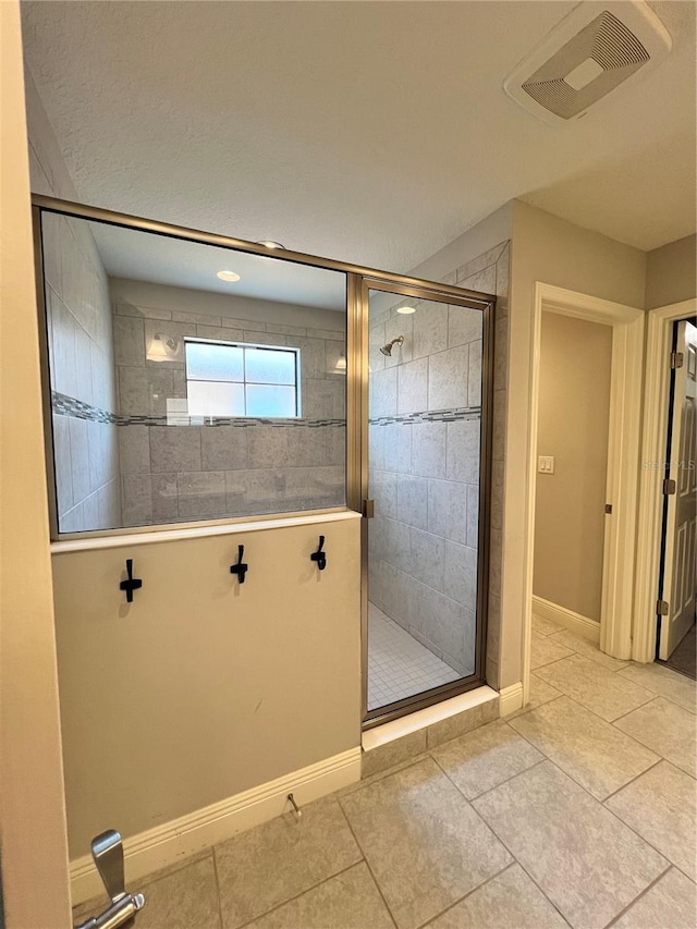 bathroom featuring an enclosed shower and tile floors