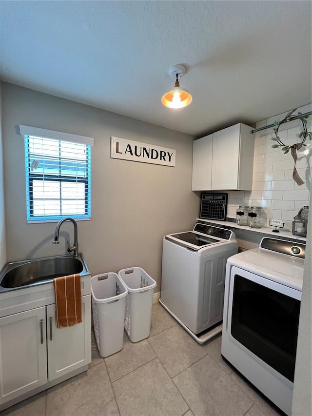 laundry area featuring independent washer and dryer, sink, cabinets, and light tile floors