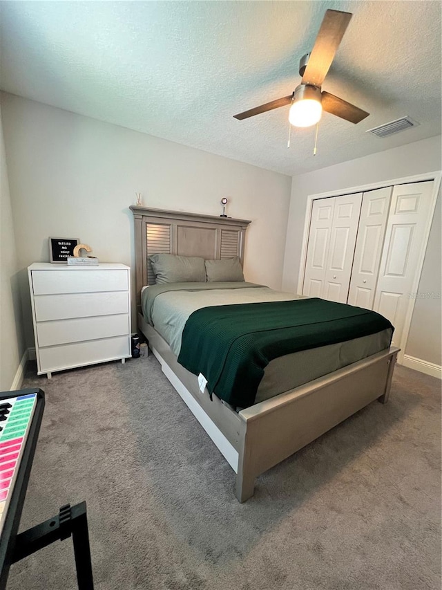 carpeted bedroom featuring a textured ceiling, a closet, and ceiling fan