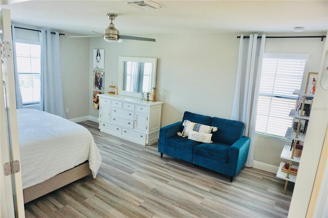 bedroom with ceiling fan, light wood-type flooring, and multiple windows