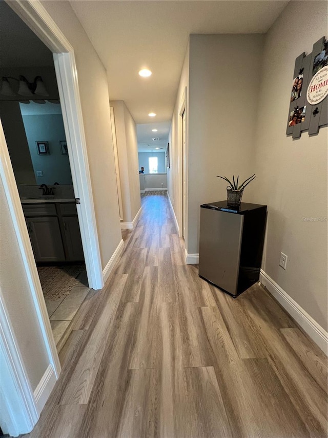 corridor featuring sink and wood-type flooring