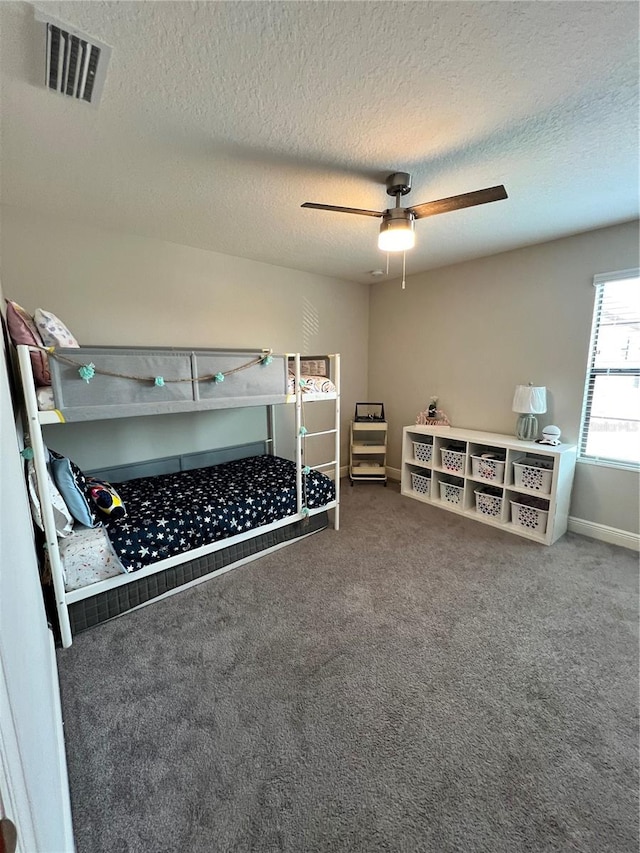 unfurnished bedroom featuring a textured ceiling, carpet flooring, and ceiling fan