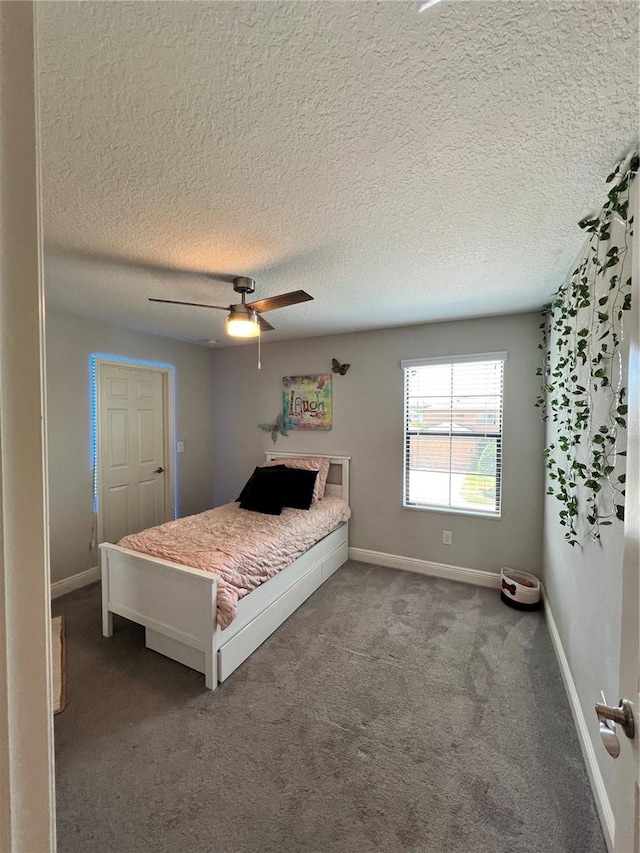 bedroom with a textured ceiling, carpet floors, and ceiling fan