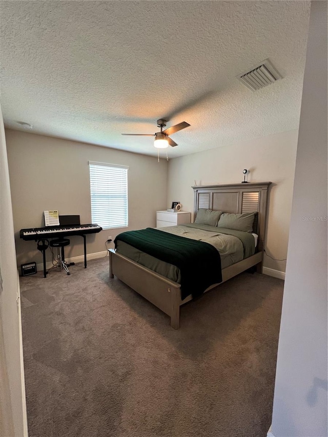 carpeted bedroom with ceiling fan and a textured ceiling