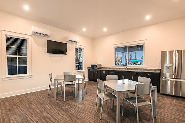 dining space with an AC wall unit and sink