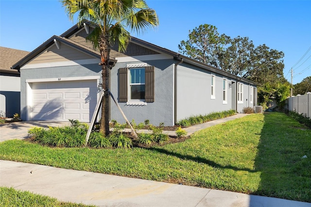 view of front of house with a front lawn, central AC unit, and a garage