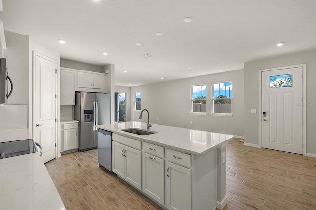 kitchen featuring a center island with sink, plenty of natural light, sink, and stainless steel appliances