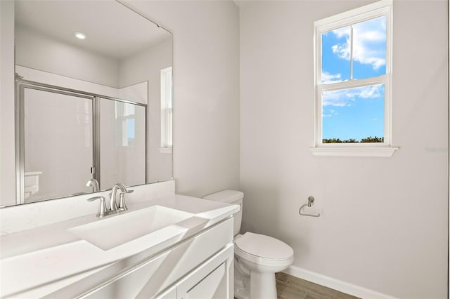 bathroom with toilet, hardwood / wood-style floors, vanity, and walk in shower