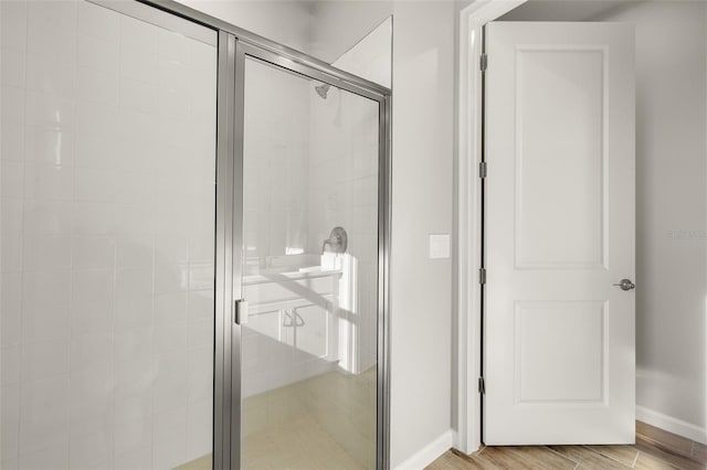 bathroom featuring a shower with door and hardwood / wood-style flooring