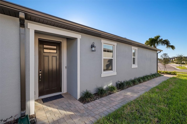 view of exterior entry featuring a yard