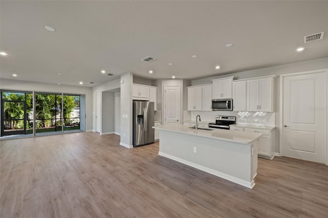 kitchen featuring sink, white cabinets, stainless steel appliances, and light wood-type flooring