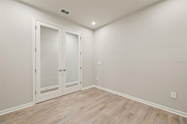 unfurnished room with french doors and light hardwood / wood-style flooring